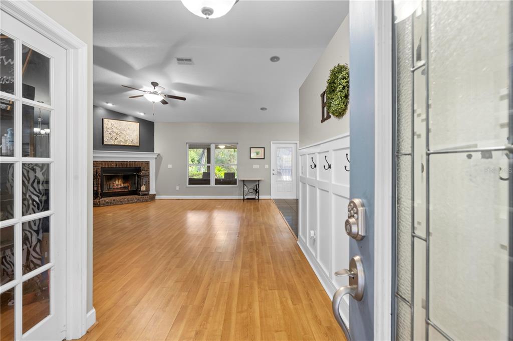 4244 Bessemer Road Brooksville, FL 34602 - Photo 42 of 56 a view of an empty room with wooden floor and a fireplace