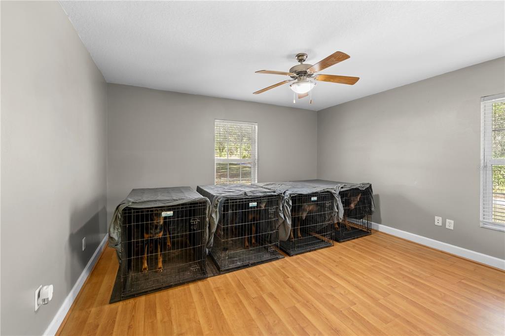 4244 Bessemer Road Brooksville, FL 34602 - Photo 43 of 56 a bedroom with a bed and wooden floor