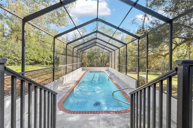 a view of a house with a yard and large trees