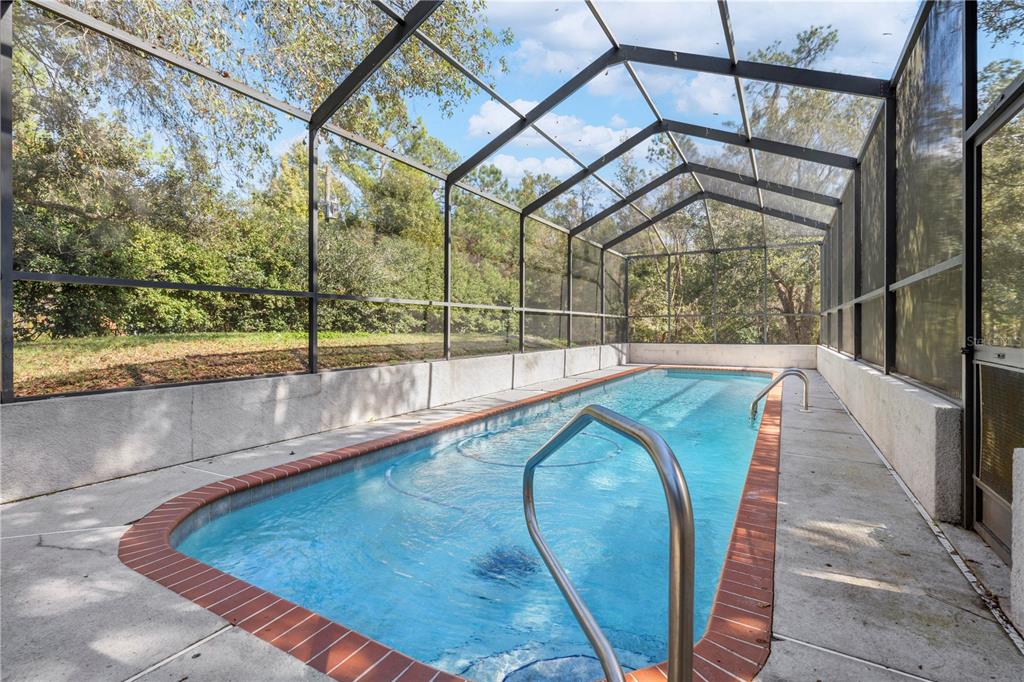 4244 Bessemer Road Brooksville, FL 34602 - Photo 51 of 56 a view of a swimming pool with a porch