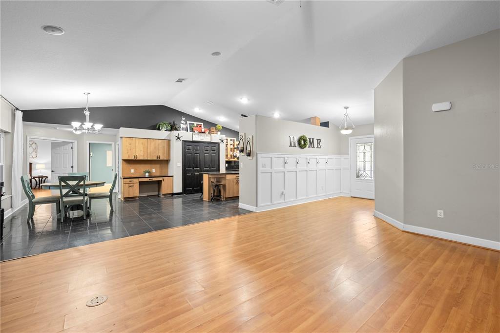 4244 Bessemer Road Brooksville, FL 34602 - Photo 9 of 56 a view of a living room and kitchen with furniture and wooden floor