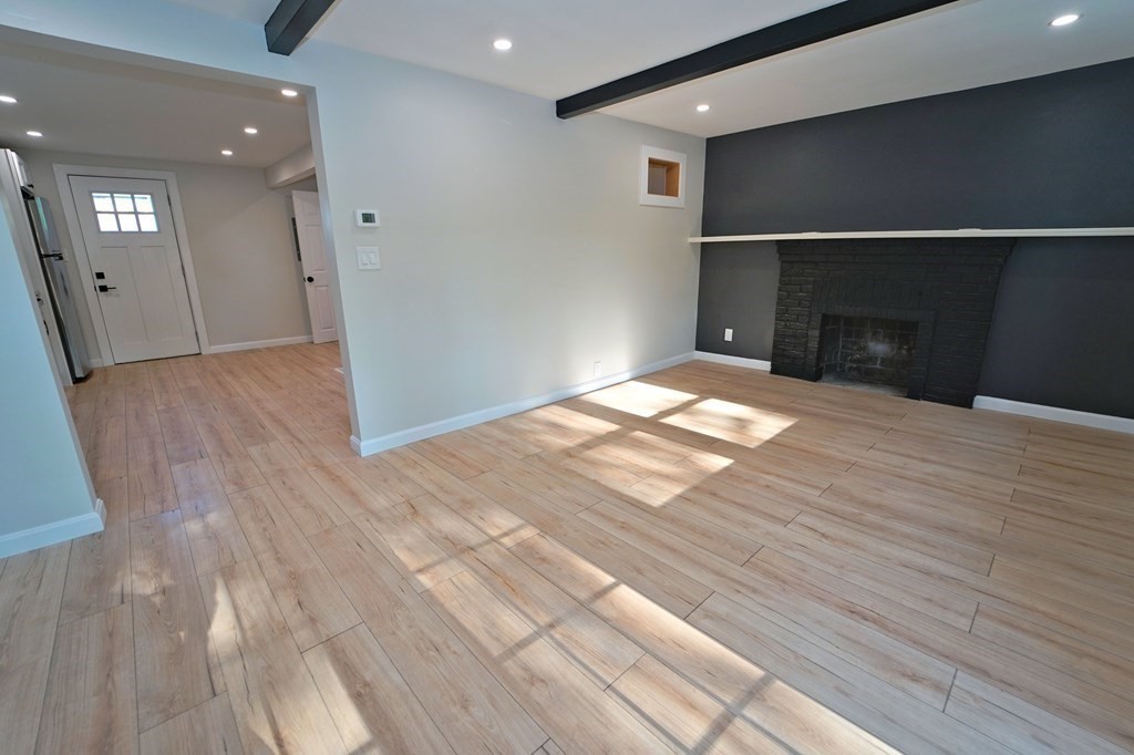 4 Juniper Road Holbrook, MA 02343 - Photo 4 of 27 a view of an empty room with wooden floor and a fireplace