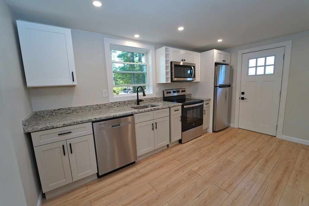 4 Juniper Road Holbrook, MA 02343 - Photo 7 of 27 a kitchen with stainless steel appliances granite countertop a stove top oven a sink dishwasher and a refrigerator with wooden floor
