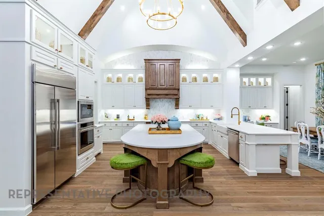 a kitchen with stainless steel appliances a dining table chairs and granite counter tops