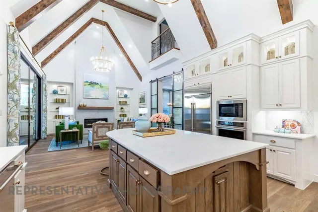 a kitchen that has a lot of cabinets a sink and a stove with wooden floor