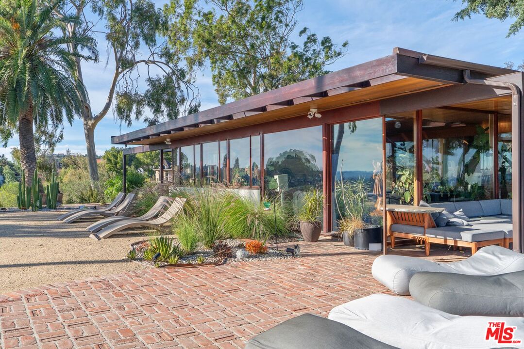 a view of backyard with swimming pool and furniture