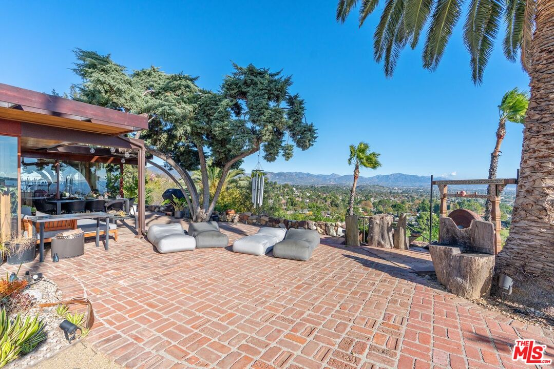 17728 Ridgeway Road Granada Hills, CA 91344 - Photo 10 of 18 a view of a patio with a dining table and chairs under an umbrella