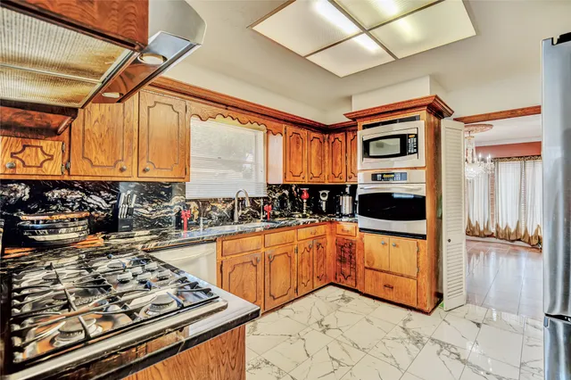 a kitchen with stainless steel appliances granite countertop a stove and a sink