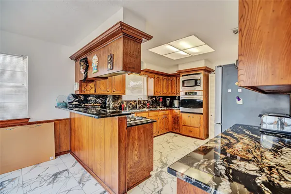 a kitchen with stainless steel appliances granite countertop a stove and a refrigerator