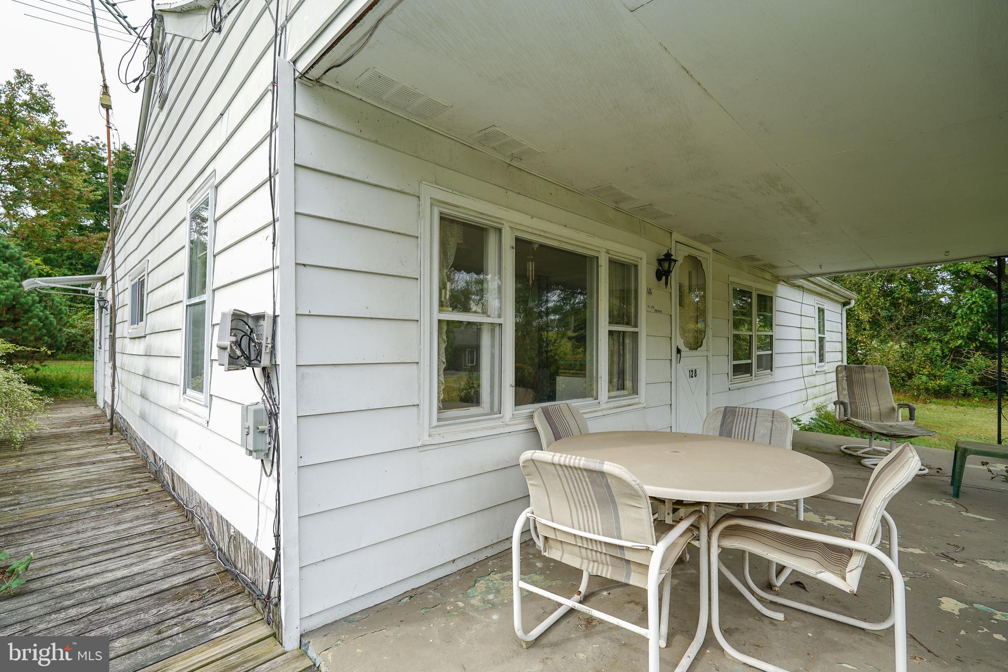 128 Woolens Road Elkton, MD 21921 - Photo 9 of 23 a view of a patio with table and chairs with wooden floor and fence