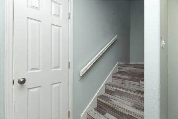 a view of staircase with railing and white walls