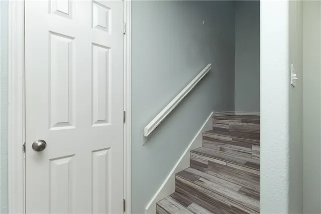 a view of staircase with railing and white walls