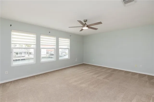 an empty room with a window and a ceiling fan