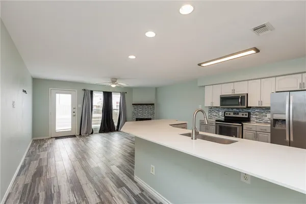 a kitchen with stainless steel appliances a refrigerator sink and stove
