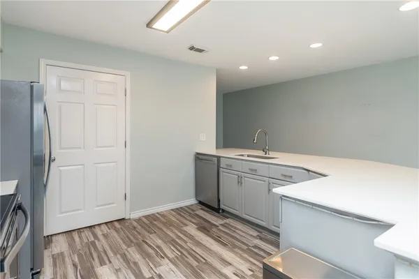 a kitchen with a sink cabinets and wooden floor