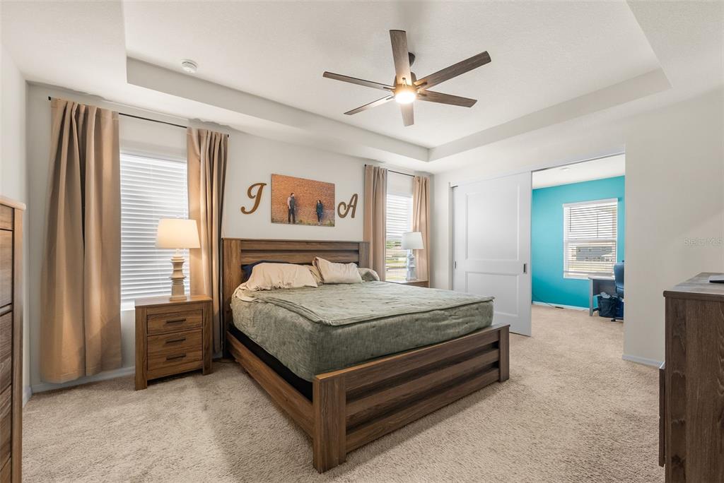 5021 Southwest 88th Street Ocala, FL 34476 - Photo 19 of 40 a bedroom with a bed a window and a chandelier