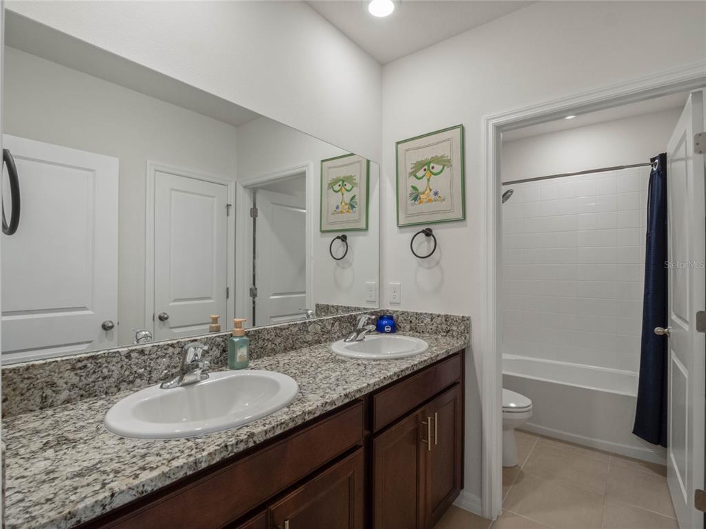 5021 Southwest 88th Street Ocala, FL 34476 - Photo 29 of 40 a bathroom with a granite countertop sink and a mirror