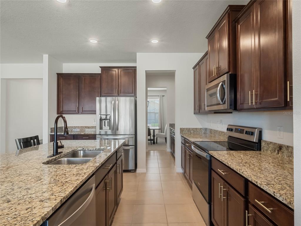 5021 Southwest 88th Street Ocala, FL 34476 - Photo 10 of 40 a kitchen with stainless steel appliances granite countertop a sink stove and refrigerator