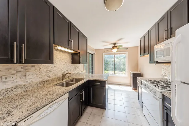 a kitchen with stainless steel appliances granite countertop a sink stove and cabinets