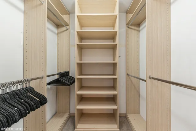 a view of walk in closet with clothes and shoes