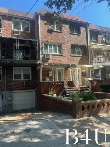 a view of a brick house with many windows and a yard