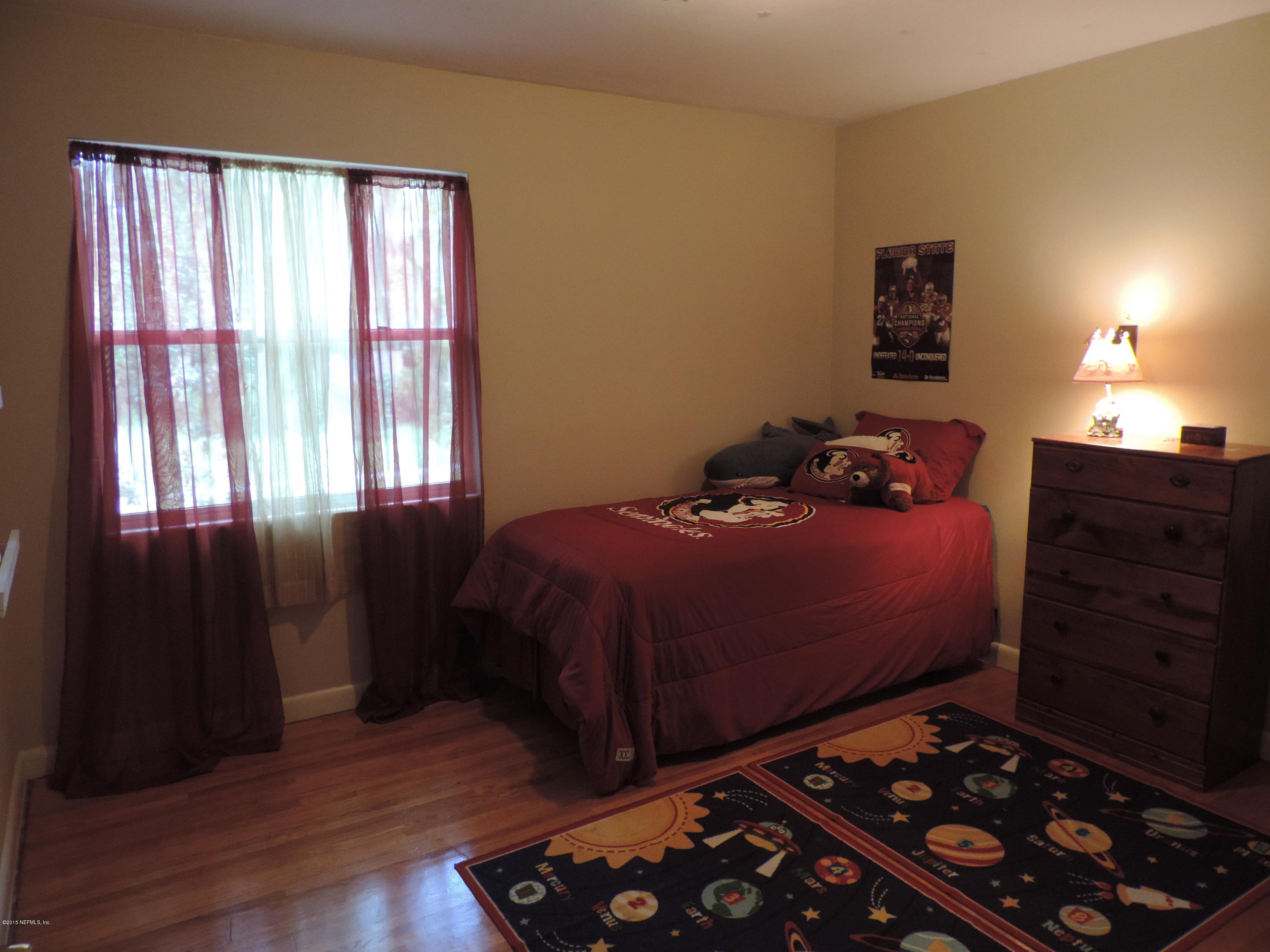 4006 Bess Road Jacksonville, FL 32277 - Photo 15 of 30 a bedroom with a bed and a dresser next to a window