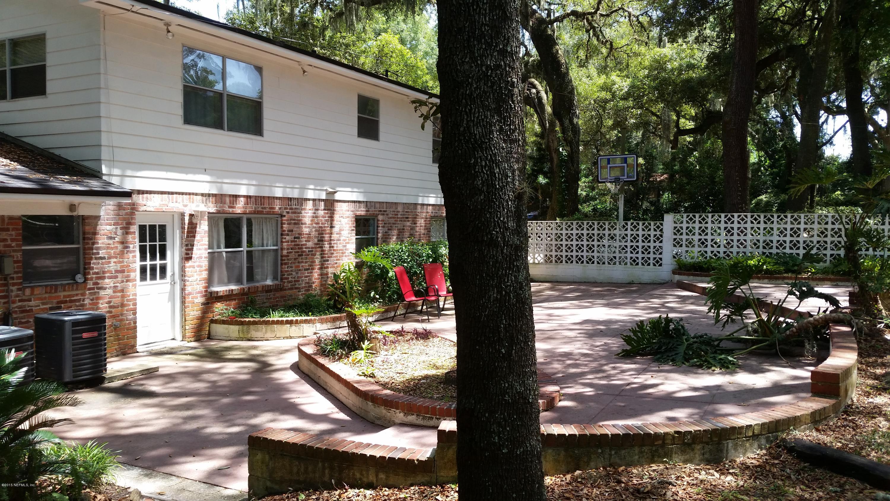 4006 Bess Road Jacksonville, FL 32277 - Photo 4 of 30 a view of a patio with table and chairs and potted plants and large tree