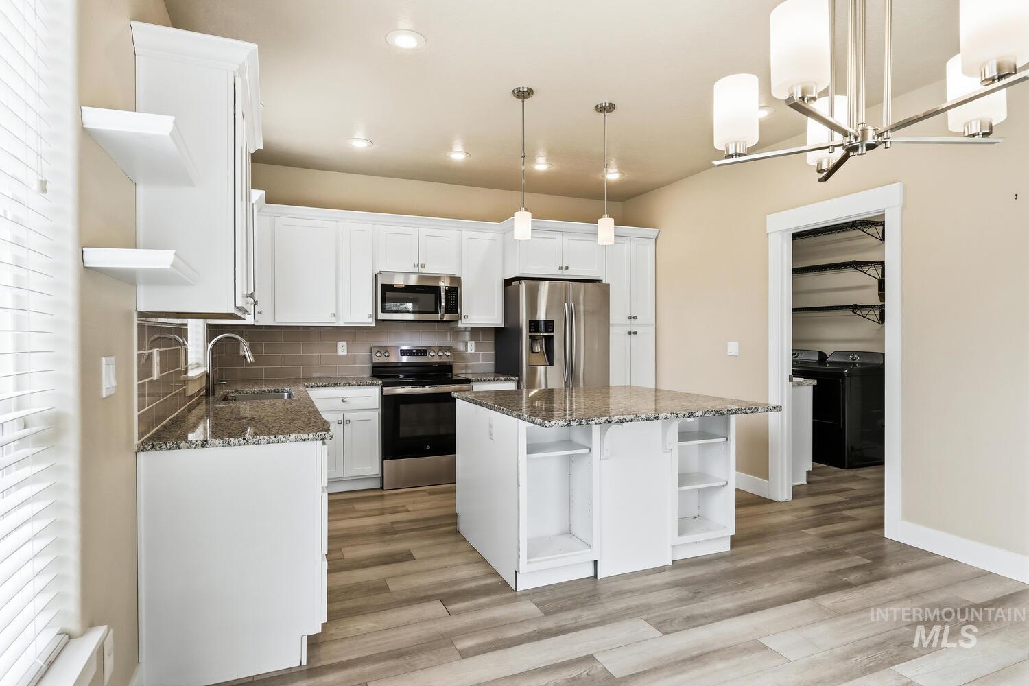 3003 West Moore Street Boise, ID 83702 - Photo 11 of 35 Kitchen with open shelves, white cabinets, dark stone countertops, and stainless steel appliances