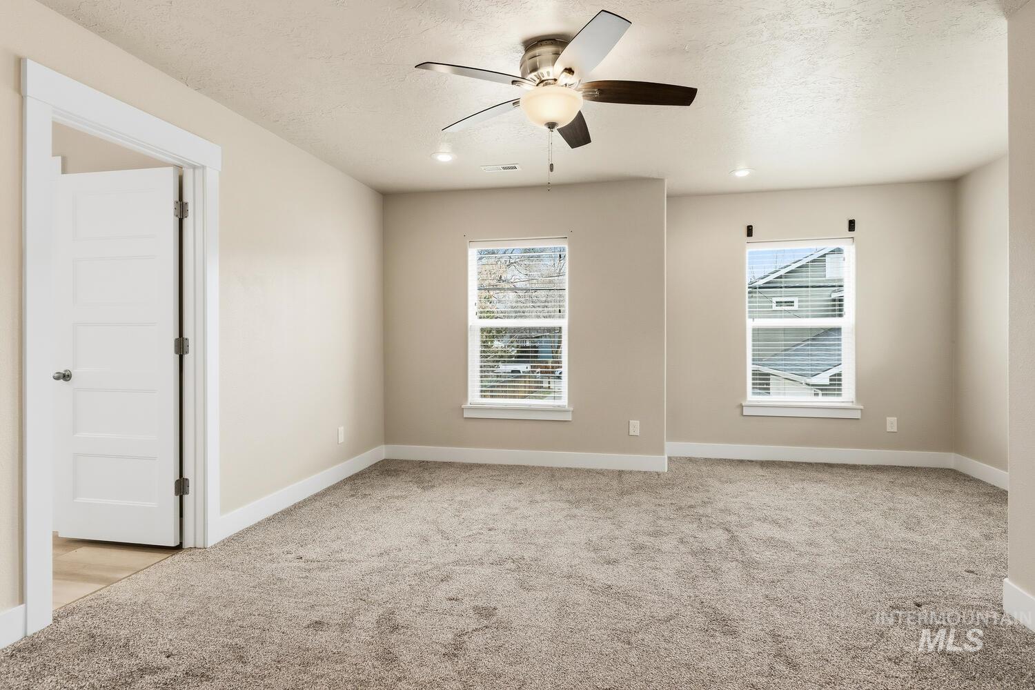 3003 West Moore Street Boise, ID 83702 - Photo 17 of 35 Empty room with light colored carpet, a ceiling fan, and recessed lighting