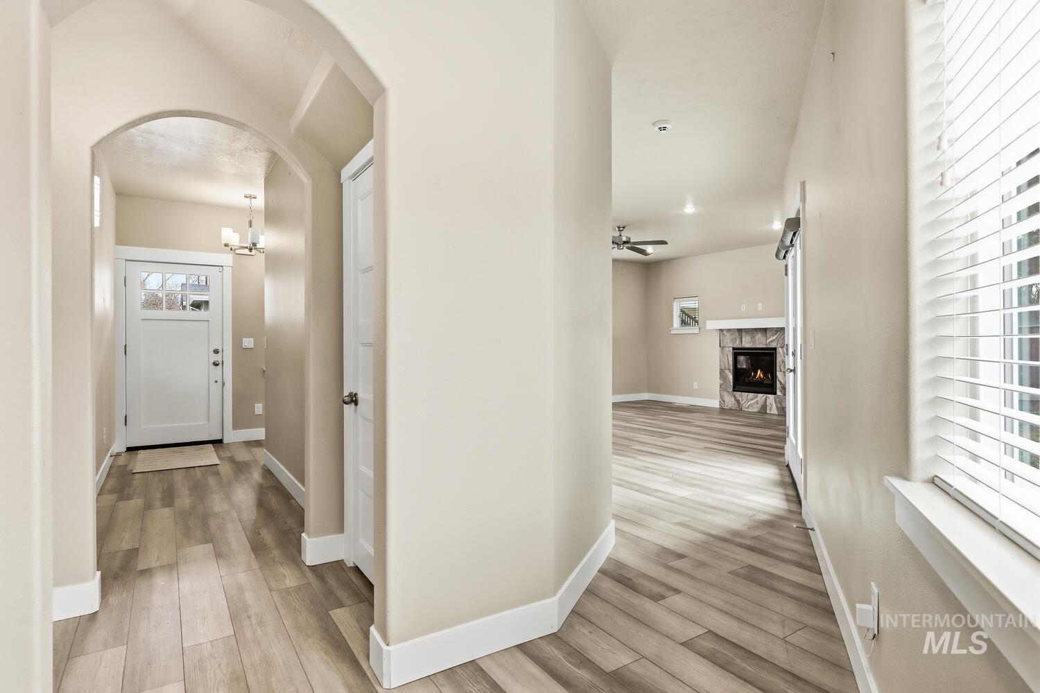3003 West Moore Street Boise, ID 83702 - Photo 3 of 35 Hallway with light wood-style floors, arched walkways, and a chandelier