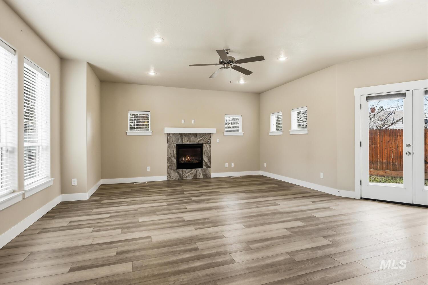 3003 West Moore Street Boise, ID 83702 - Photo 6 of 35 Unfurnished living room featuring french doors, ceiling fan, light wood-type flooring, a premium fireplace, and recessed lighting