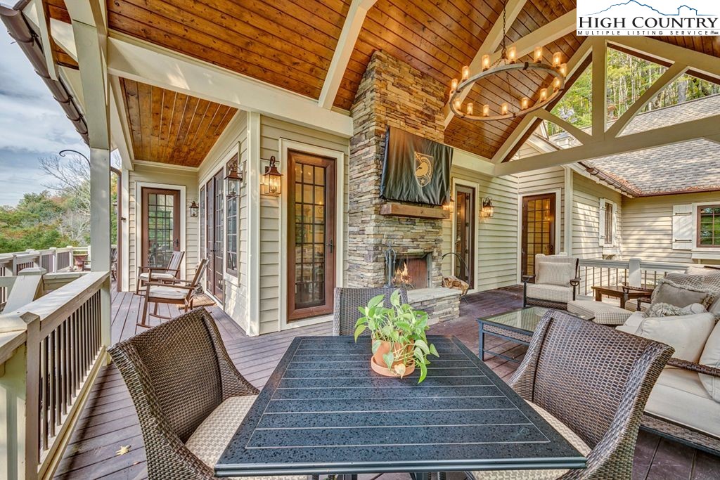 906 Fox Meadow Road Banner Elk, NC 28604 - Photo 14 of 40 a view of a patio with couches chairs and wooden floor