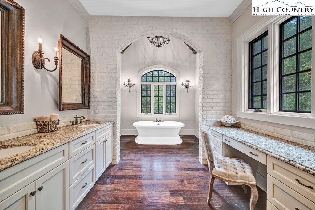 906 Fox Meadow Road Banner Elk, NC 28604 - Photo 17 of 40 a spacious bathroom with a granite countertop tub a double vanity sink and a window