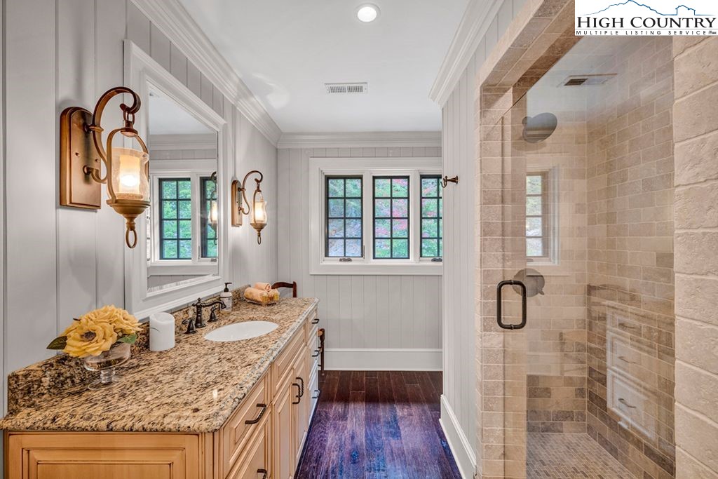 906 Fox Meadow Road Banner Elk, NC 28604 - Photo 26 of 40 a bathroom with a granite countertop sink a mirror a vanity and a shower