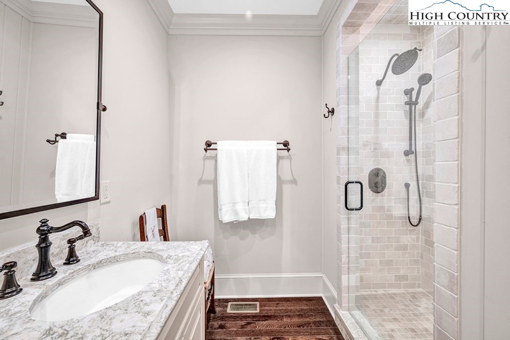 906 Fox Meadow Road Banner Elk, NC 28604 - Photo 31 of 40 a bathroom with a granite countertop shower sink and mirror