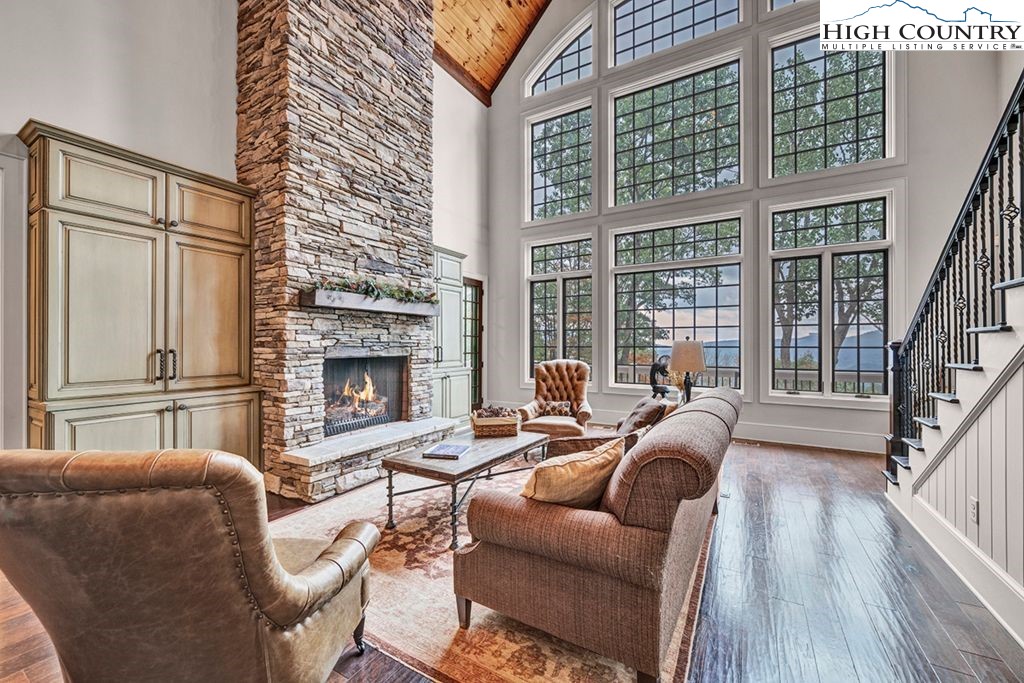 906 Fox Meadow Road Banner Elk, NC 28604 - Photo 6 of 40 a living room with furniture large windows and wooden floor