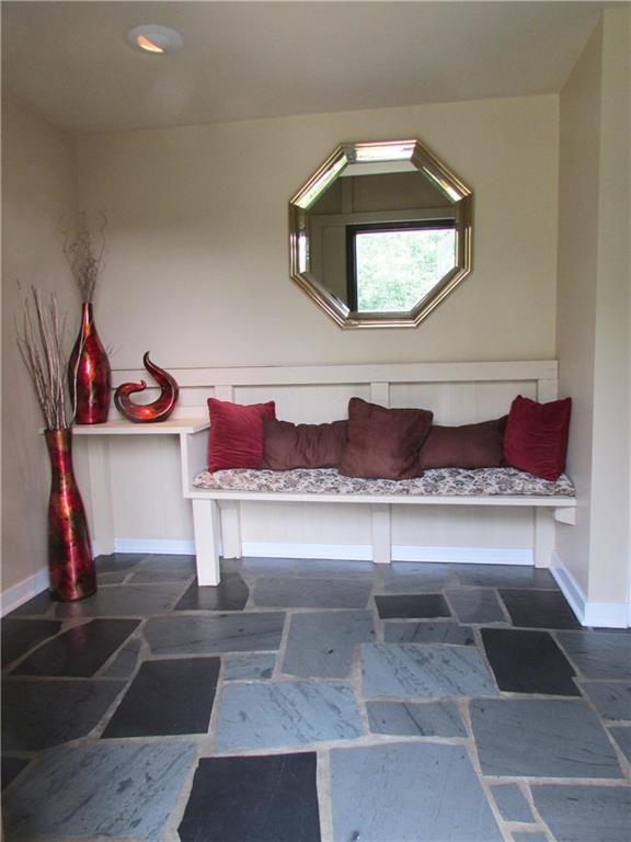 ENTRY - Slate floors, recessed lighting, and custom bench welcome guest into the large and bright foyer.