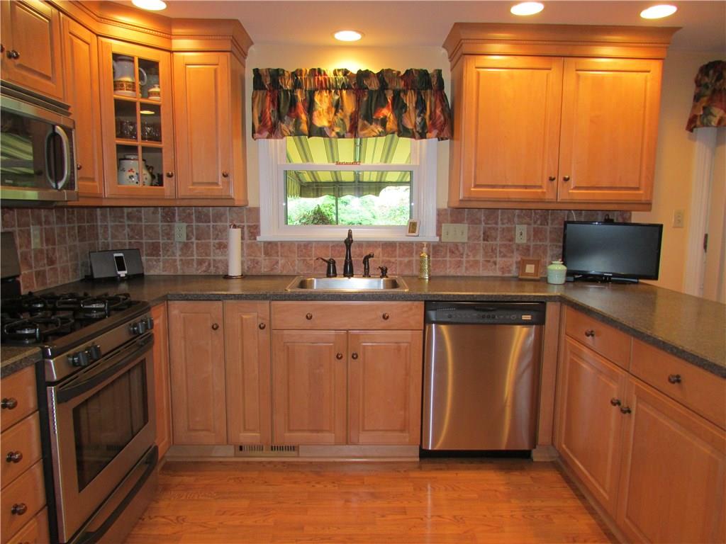 KITCHEN - Abundant maple cabinets, Wilsonart counters by Vangura, recessed lighting and stainless steel appliances make the remodeled kitchen a dream to prepare meals or entertain.