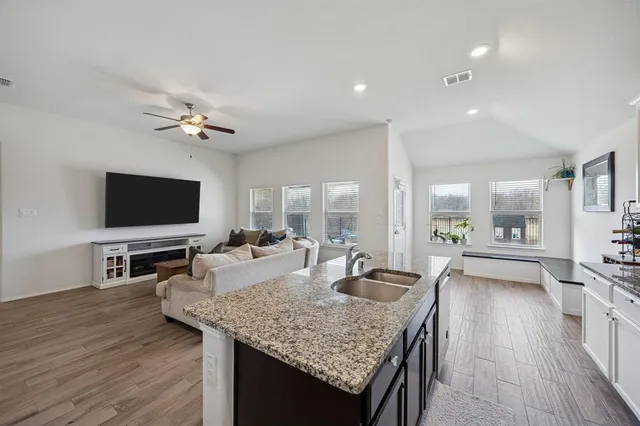 a living room with granite countertop furniture and a flat screen tv