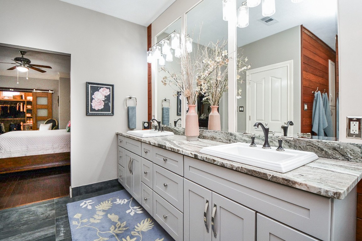 3680 Eula Morgan Road Katy, TX 77493 - Photo 19 of 50 Rustic granite counters give an earthy feel to the dual-sink primary ensuite bathroom console; with lovely mirrored walls and delicate lighting above, and tons of handy storage, below.