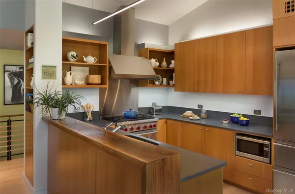 a kitchen with stainless steel appliances a sink dishwasher and cabinets with wooden floor
