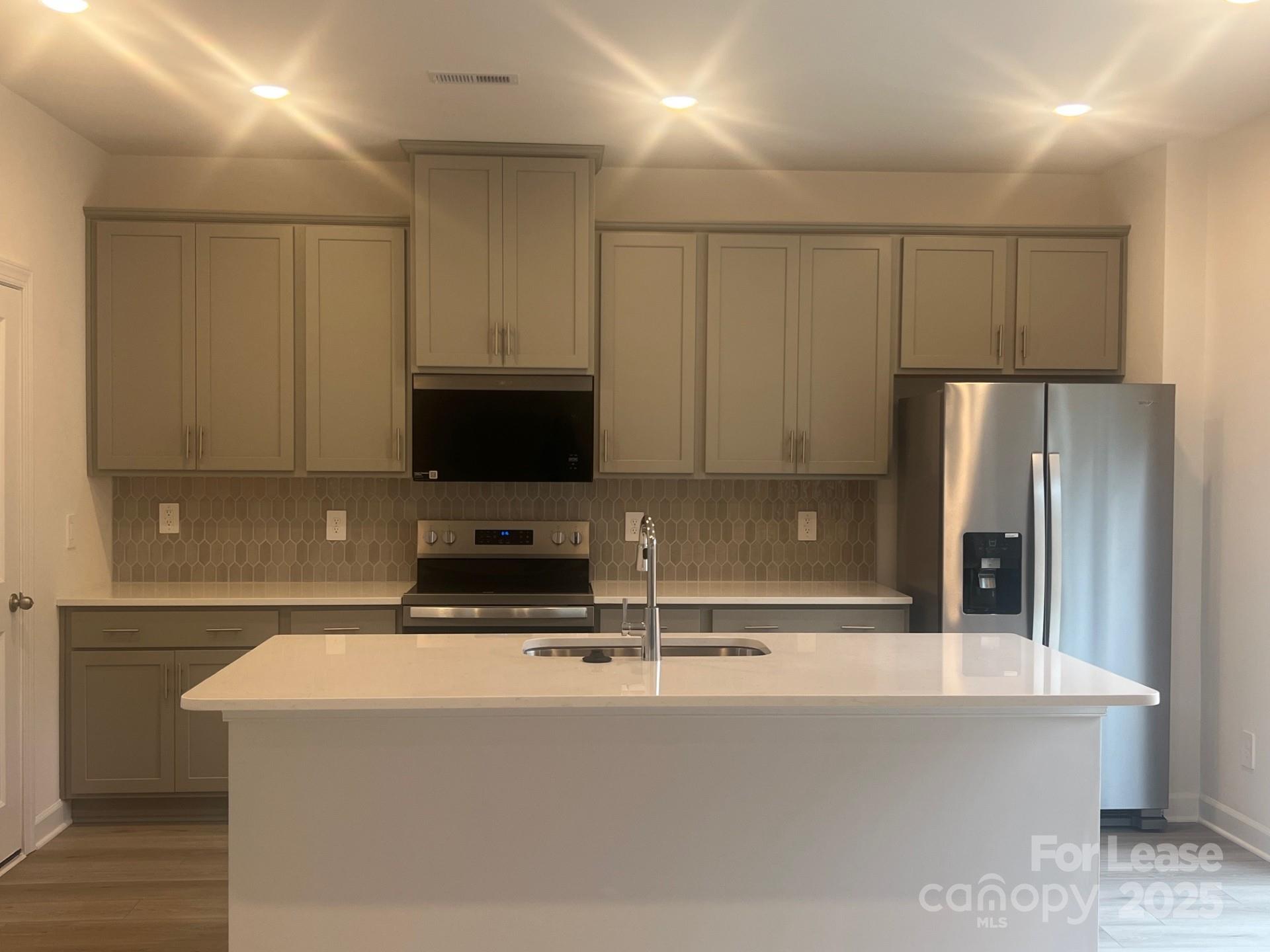 1241 30th St Lane Northeast Conover, NC 28613 - Photo 3 of 19 a kitchen with kitchen island a sink a stove and a refrigerator