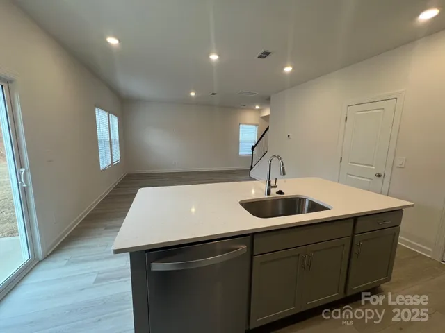 a kitchen with a sink and wooden floor