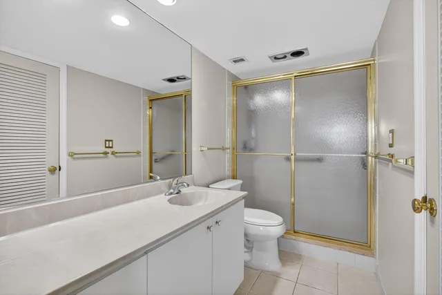 a bathroom with a shower sink vanity mirror and toilet