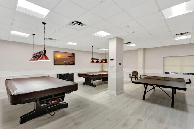 a room with furniture pool table and window