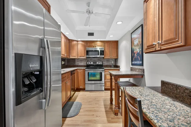a kitchen with stainless steel appliances granite countertop a refrigerator and a stove top oven