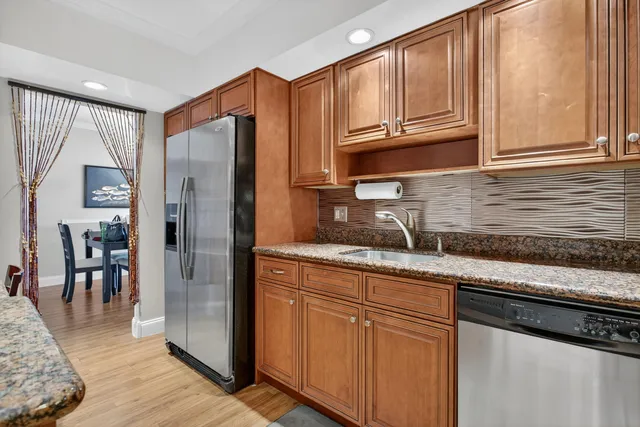 a kitchen with stainless steel appliances granite countertop a refrigerator and cabinets