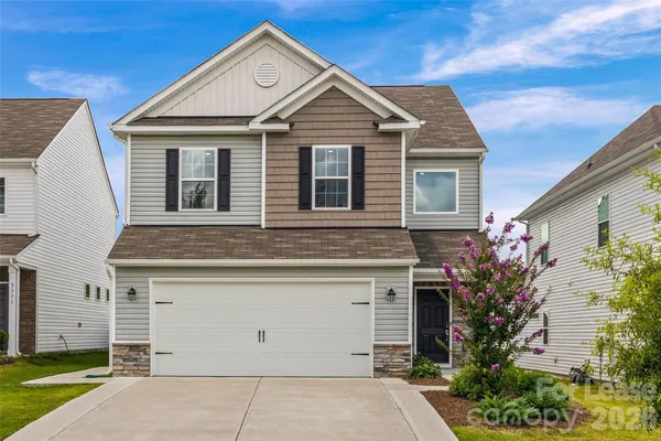 a front view of a house with a garden