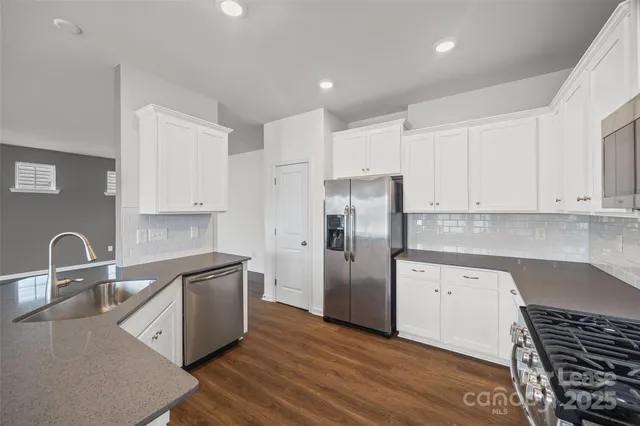 a kitchen with white cabinets and stainless steel appliances