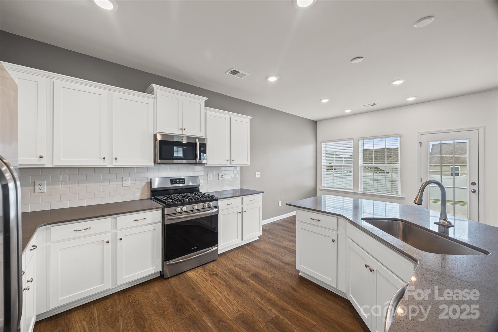 5775 Soft Shell Drive Lancaster, SC 29720 - Photo 15 of 39 a kitchen with granite countertop white cabinets and stainless steel appliances